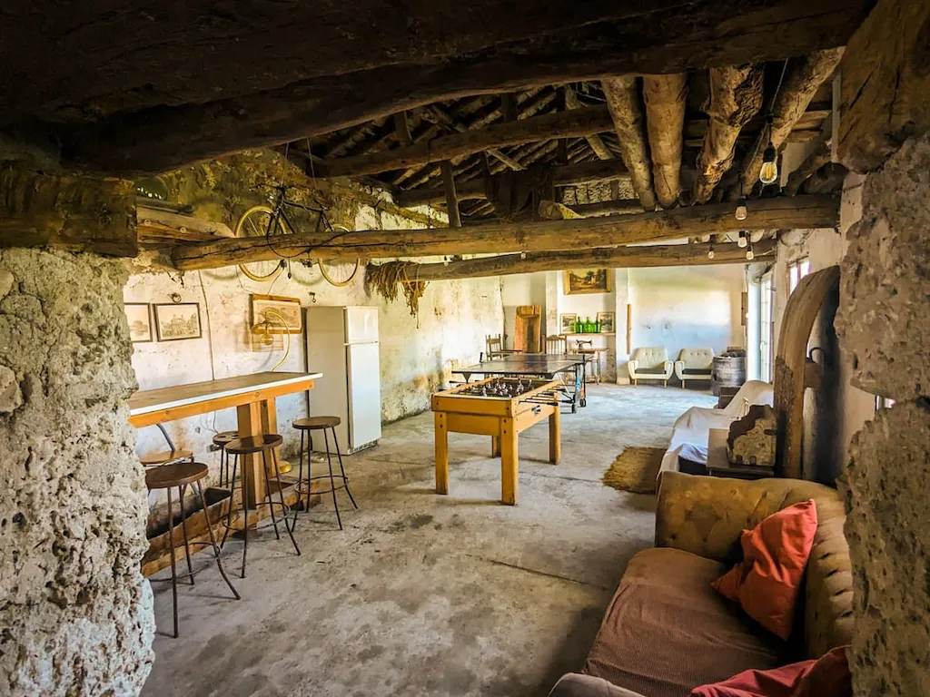 Sala con barra de bar, futbolín, mesa de pingpong, frigorífico y sofás