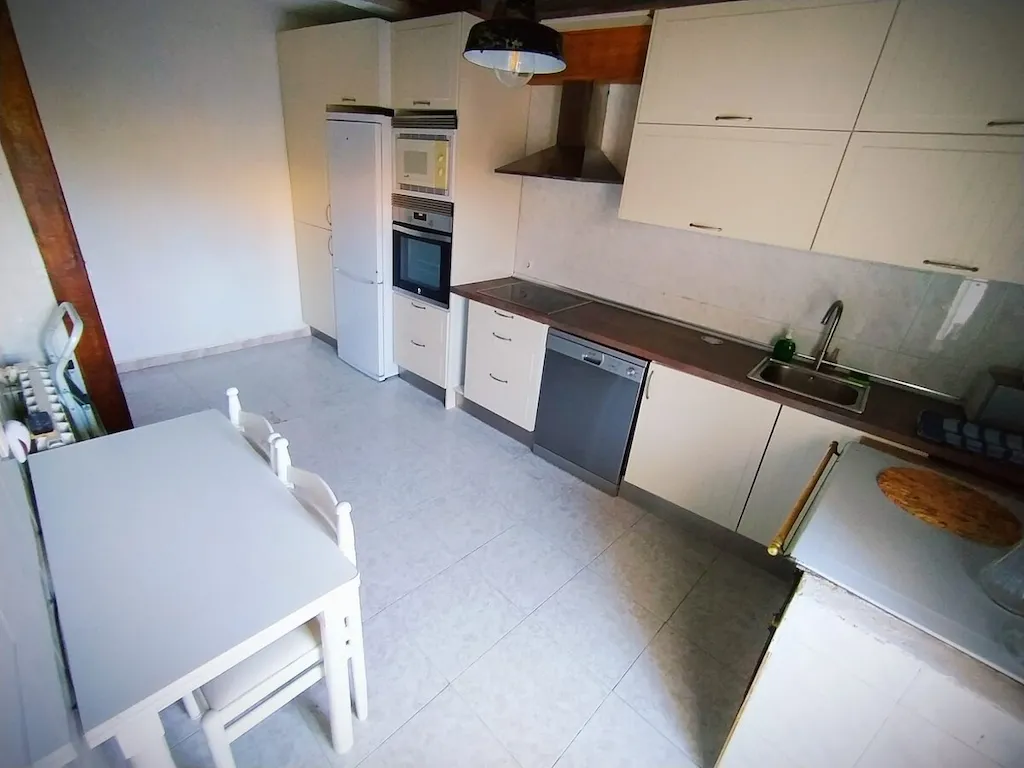 Cocina amplia con electrodomésticos y mesa