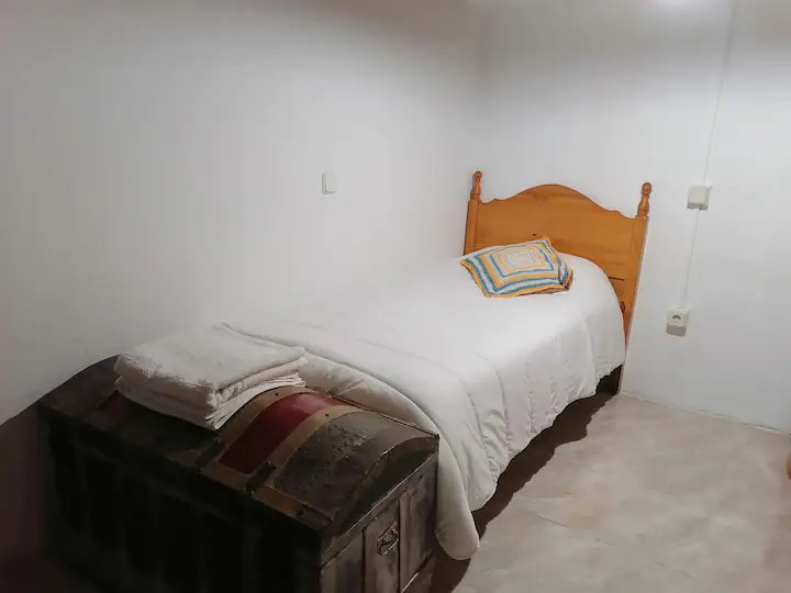 Cama individual con baúl a los pies